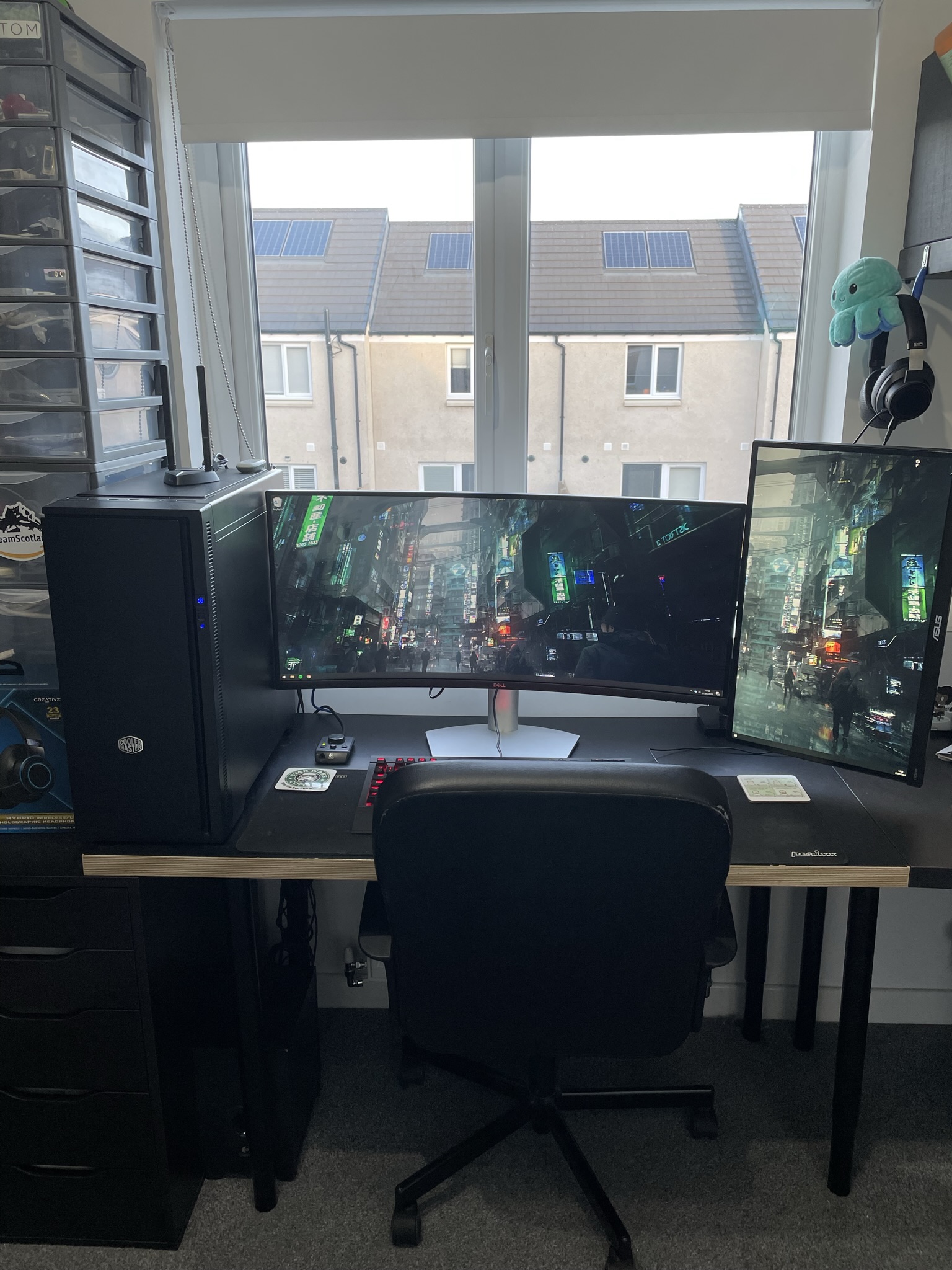 A computer workstation with PC tower, ultrawide monitor and a portrait monitor